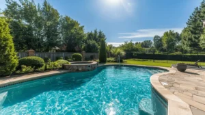 Backyard pool with stone details and greenery.