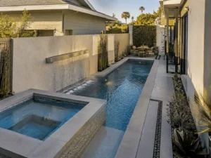 Narrow geometric pool with an integrated spa and dining area