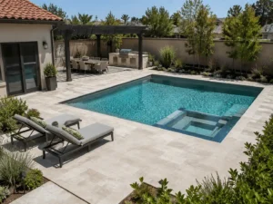 Light stone pool deck with dining, cooking, and lounging zones